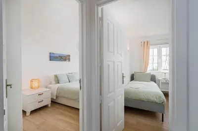 a white room with two beds and a window at Sweet Old Village in Quarteira