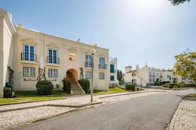 an empty street in front of a white building at Sweet Old Village in Quarteira