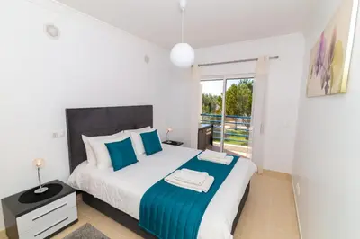 a bedroom with a large bed with blue pillows at Albufeira Sunny Apartment 2 With Pool by Homing in Galé