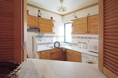 a kitchen with wooden cabinets and a white appliances at Vilamoura Marina Extraordinary 70 m2 T1, Marina 200m , beach 300m in Vilamoura