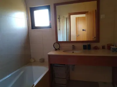 a bathroom with a tub and a sink and a mirror at J&J Home T2 next to Pinhal Velho, Terraces of Pinhal, Vilamoura in Quarteira