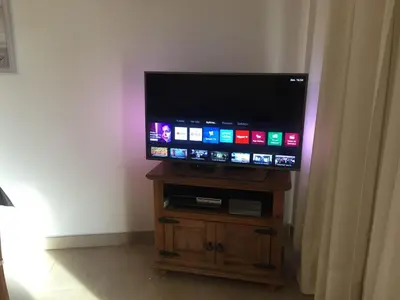 a flat screen tv sitting on top of a wooden stand at J&J Home T2 next to Pinhal Velho, Terraces of Pinhal, Vilamoura in Quarteira