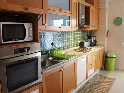 a kitchen with a sink and a microwave at J&J Home T2 next to Pinhal Velho, Terraces of Pinhal, Vilamoura in Quarteira