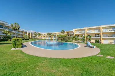 a swimming pool in the middle of a building at Jardins da Marina BI Albufeira Marina in Albufeira