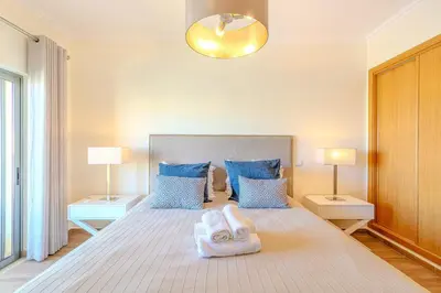 a bedroom with a bed with two towels on it at Jardins da Marina BI Albufeira Marina in Albufeira