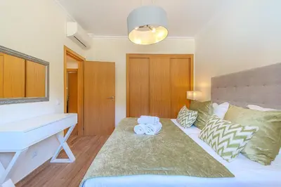 a bedroom with a bed with a desk and a piano at Jardins da Marina BI Albufeira Marina in Albufeira
