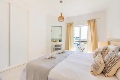 a living room with a blue couch and a tv at Albufeira Family Holidays with Pool View in Albufeira