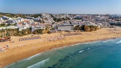 a large swimming pool in front of a blue building at Albufeira Family Holidays with Pool View in Albufeira