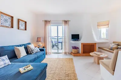 a door to a balcony with chairs and a plant at Albufeira Family Holidays with Pool View in Albufeira