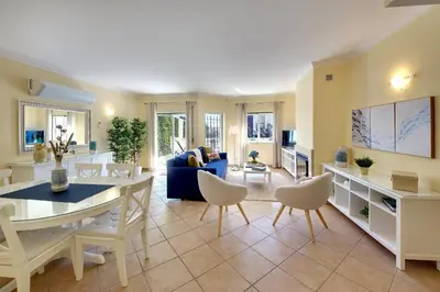 a living room with a couch and a table and chairs at Eagle Eye Villa in Albufeira
