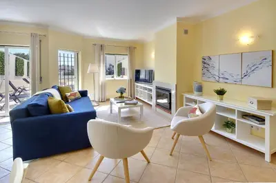 a living room with a blue couch and chairs at Eagle Eye Villa in Albufeira