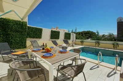 a patio with a table and chairs next to a pool at Eagle Eye Villa in Albufeira