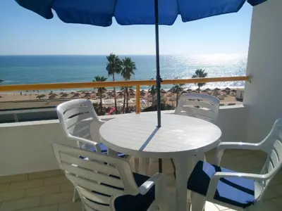 a table and chairs with a view of the beach at T1 Praiamar 4 Vista Magnifica in Quarteira