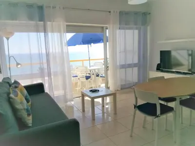 a living room with a couch and a table with a view at T1 Praiamar 4 Vista Magnifica in Quarteira