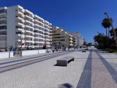 a row of apartment buildings on a street with a bench at T1 Praiamar 4 Vista Magnifica in Quarteira