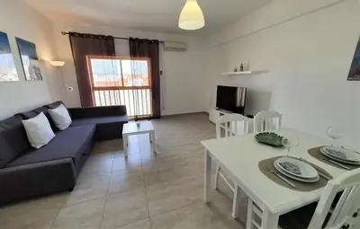 a living room with a couch and a table at T1 Dunas 7 - Aconchegante, Wifi, 150mt Praia in Quarteira