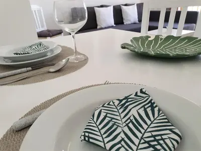 a white table with a plate and a glass at T1 Dunas 7 - Aconchegante, Wifi, 150mt Praia in Quarteira