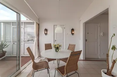 a dining room with a white table and chairs at Panoramic Faro Apartment in Faro