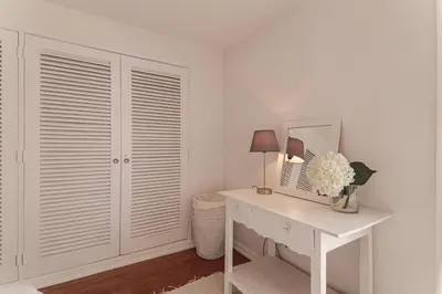 a white room with a desk and a mirror at Panoramic Faro Apartment in Faro