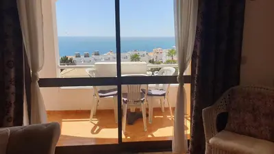 a room with a table and chairs and a view of the ocean at Sunset Seaviews Albufeira in Albufeira
