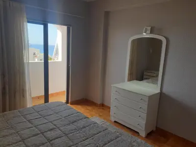a bedroom with a bed and a mirror and a window at Sunset Seaviews Albufeira in Albufeira