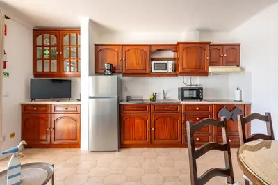 a kitchen with a refrigerator and a view of the ocean at Sunset Azul - Sea View - Free Wifi - By Bedzy in Albufeira