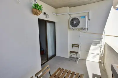 a room with a balcony with a microwave and a chair at Go4Portugal - Vilamagna - Luxe Condo with Pool, Airco and Seaview Balcony in Albufeira