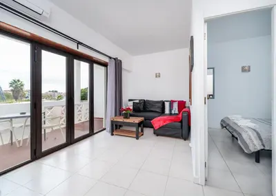 a living room with a couch and a balcony at 1 bedroomed Apartment - Ocean View - Oura - Beach in Albufeira