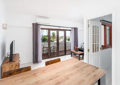 a dining room with a wooden table and a view of a patio at 1 bedroomed Apartment - Ocean View - Oura - Beach in Albufeira