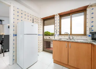 a kitchen with a white refrigerator and windows at 401 - 2 bedroom Apartment - Oura - Sea View in Albufeira