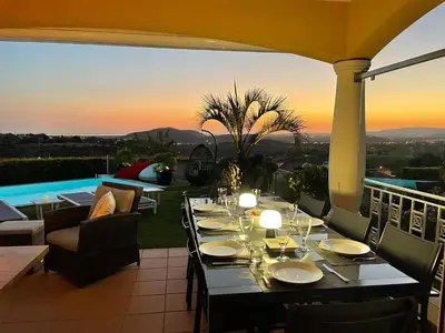 a view of a swimming pool at sunset at Casa Das Palmeiras in Loulé