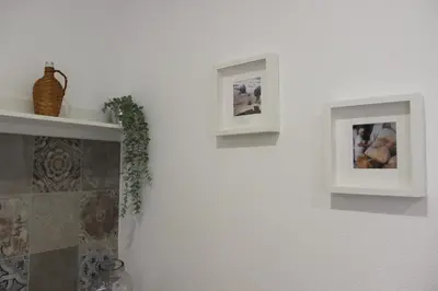 two pictures on a white wall with a shelf at Quinta do Sr. Cabrita in Albufeira