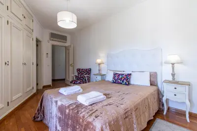 a bedroom with a large bed with two towels on it at Villa Brisa do Mar in Galé