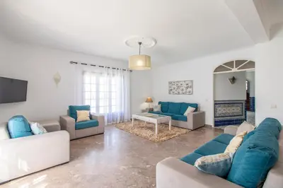 a dining room with a table and a chandelier at Villa Brisa do Mar in Galé