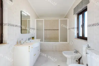 a white bathroom with a sink and a mirror at Villa Margarida - heatable pool & city center in Albufeira