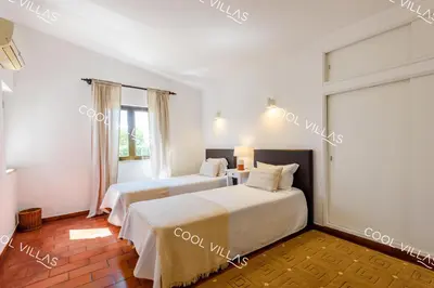 two beds in a room with white walls at Villa Margarida - heatable pool & city center in Albufeira
