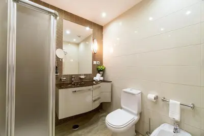a white bathroom with a toilet and a sink at Histórical City Center Penthouse Albufeira in Albufeira