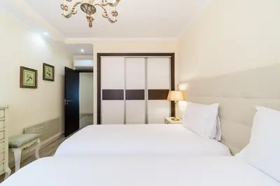 a bedroom with two beds and a chandelier at Histórical City Center Penthouse Albufeira in Albufeira