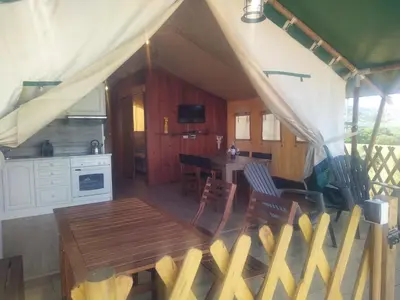 a kitchen and dining room of a tent with a table at Pérola de Sandy in Paderne