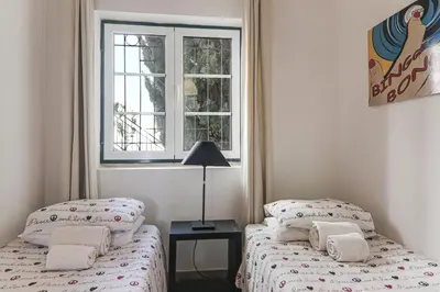 a bedroom with two beds and a window at Old Village Vilamoura in Quarteira