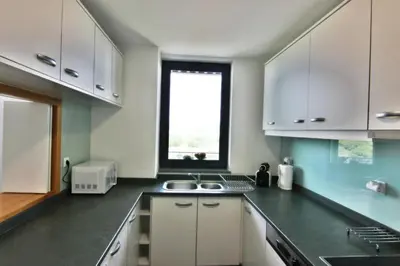a kitchen with white cabinets and a sink and a window at Residences Golf Club Apartment in Quarteira