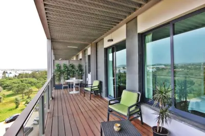 a balcony with a table and chairs and windows at Residences Golf Club Apartment in Quarteira