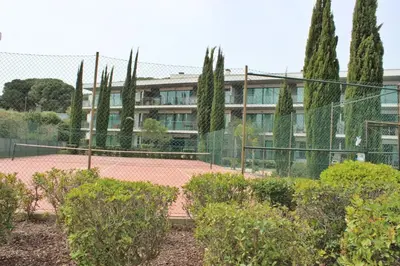 a fence in front of a building with trees at Residences Golf Club Apartment in Quarteira