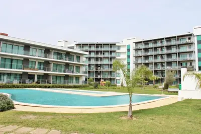 a swimming pool in front of a large apartment building at Residences Golf Club Apartment in Quarteira