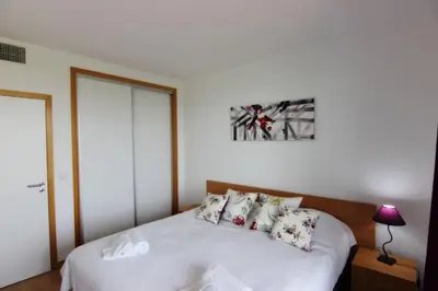 a bedroom with a bed with white sheets and pillows at Residences Golf Club Apartment in Quarteira