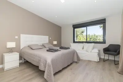 a bedroom with a bed and a chair and a window at Villa Isabelle - Loule in Loulé
