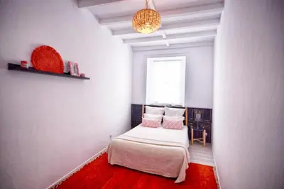 a small bedroom with a bed and a window at Old Charming Faro Apartment in Faro