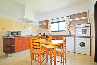 a kitchen with a table and chairs and a sink and a dishwasher at Villa Ushuaia by Algarve Vacation in Guia