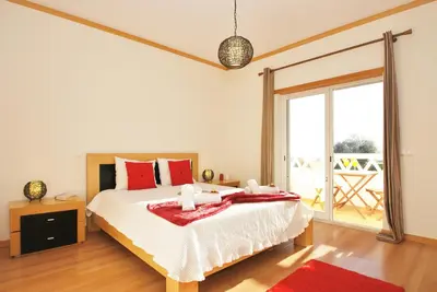 a bedroom with a large bed with red pillows at Townhouse Mar 2 by Algarve Vacation in Albufeira