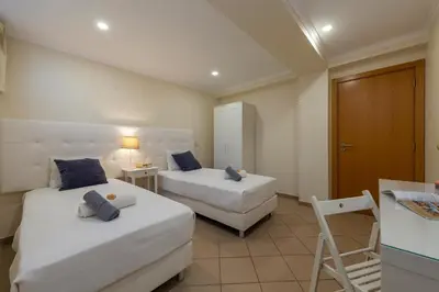 a hotel room with two beds and a chair at Villa Florida by Algarve Vacation in Albufeira